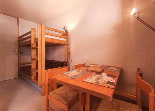- une salle à manger avec une table et des lits superposés dans l'établissement Résidence Roches Blanches G - ROCHES BLANCHES 35 MAE-6571, à Valmorel