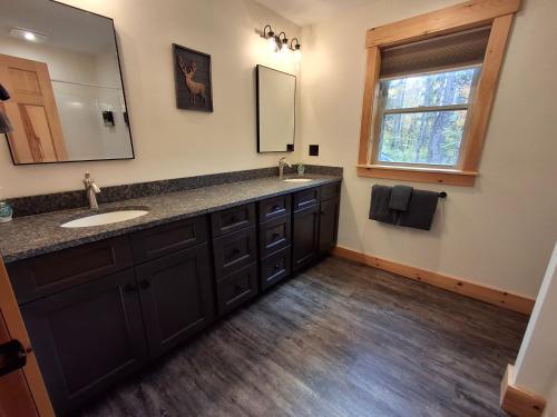 a bathroom with a sink and a mirror at Scoot Cabin - Dogs Welcome! in Carrabassett