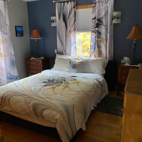 a bedroom with a bed with white sheets and a window at Le Gite de la Renarde in Saint-Félix-d'Otis