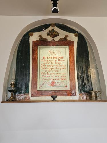 an archway with a framed picture on a wall at Maison historique du XVIIIème siècle in Mouzay