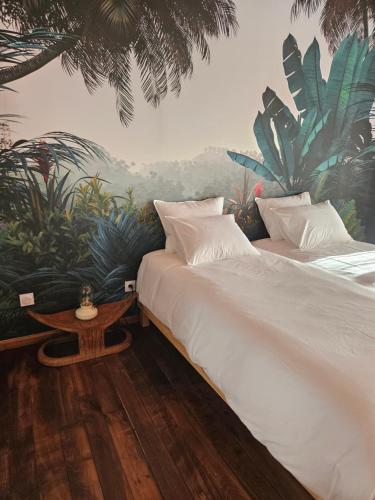 a bedroom with two beds and a mural of plants at Maison historique du XVIIIème siècle in Mouzay