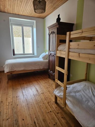 a bedroom with two bunk beds and a window at Maison historique du XVIIIème siècle in Mouzay