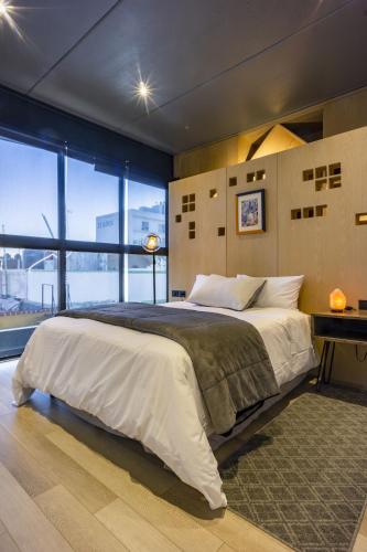 a bedroom with a large bed and a large window at HERMOSO Departamento Boutique en Centro de Puebla in Puebla