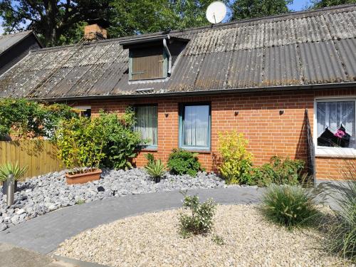 ein Backsteinhaus mit einem Kieshof davor in der Unterkunft Ferienwohnungen Auetal in Kucksdorf
