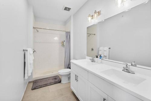 a white bathroom with a sink and a toilet at Supreme 2 Bedroom Condo in Prime Jersey City in Jersey City