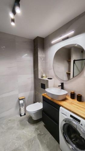a bathroom with a sink and a washing machine at Apartament Park Chorzów, FV, parking podziemny, zamknięte osiedle in Chorzów