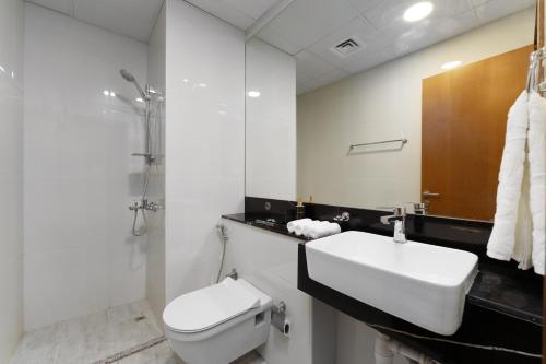 a white bathroom with a sink and a toilet at Business Bay Gem , Burj Khalifa View in Dubai