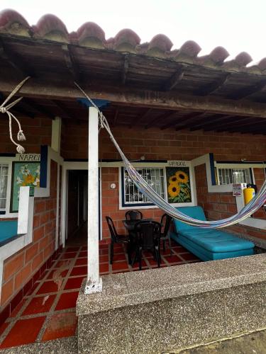 a house with a patio with a table and chairs at Yarumito Finca Hotel l Cabaña Girasol in Barbosa