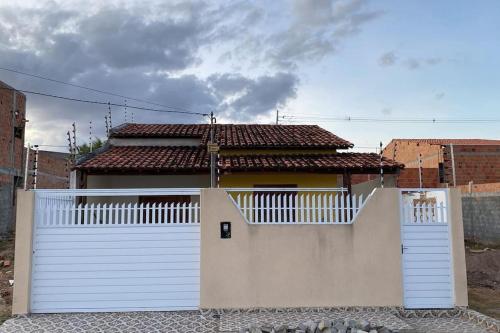 a house with a white gate and a white fence at Casa Cactos in Piranhas