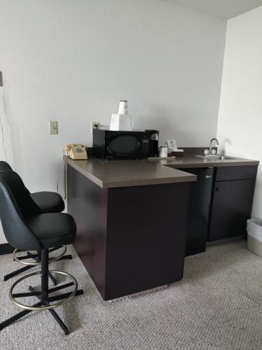 a black desk with a chair and a microwave at America's Best Value Inn & Suites International Falls in International Falls