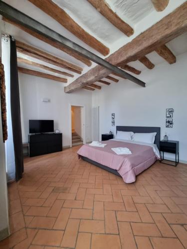 a bedroom with a large bed in a room with wooden ceilings at 35 Rooms Palazzo Buoninsegni in Colle Val D'Elsa