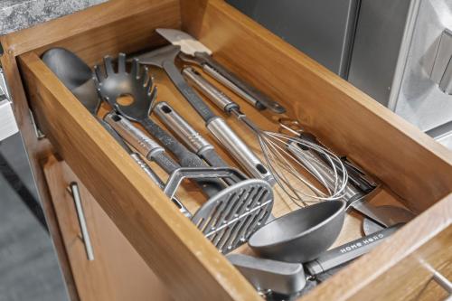 a wooden drawer filled with utensils and spatulas at 202-DT Luxe Comfy & Huge Loft Wi-Fi Parking Cafe in Cleveland