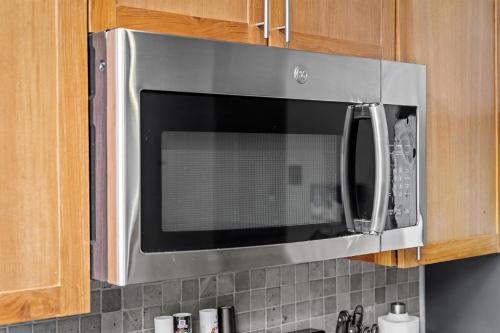 a microwave oven hanging from a kitchen cabinets at 202-DT Luxe Comfy & Huge Loft Wi-Fi Parking Cafe in Cleveland