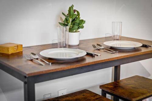 a table with two plates and silverware on it at 202-DT Luxe Comfy & Huge Loft Wi-Fi Parking Cafe in Cleveland