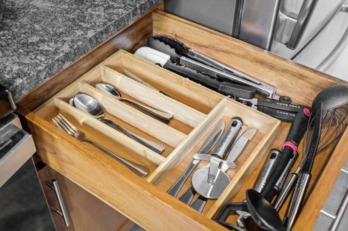 a wooden drawer filled with knives and utensils at 202-DT Luxe Comfy & Huge Loft Wi-Fi Parking Cafe in Cleveland