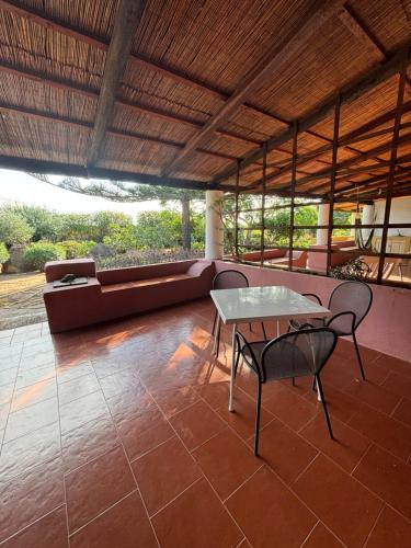 a patio with a table and chairs and a couch at Villa La Rosa in Filicudi