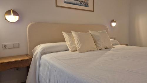 a bedroom with a bed with white sheets and pillows at Suite Haus Castelar in Santander