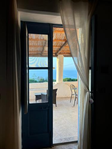 an open door to a patio with a view of the beach at Villa La Rosa in Filicudi