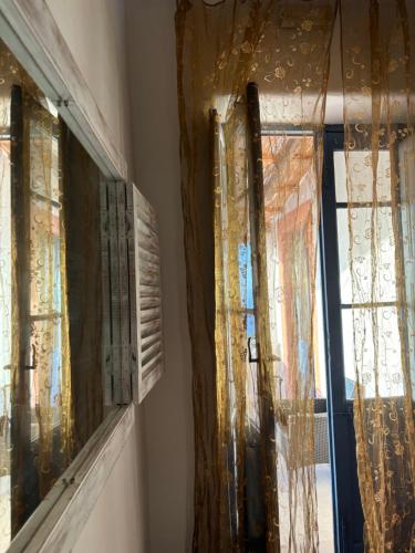 two windows with lace curtains in a room at Villa La Rosa in Filicudi
