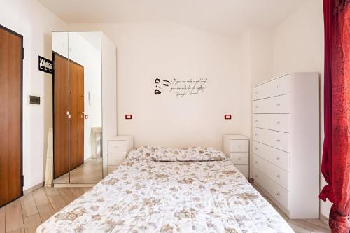 a white bedroom with a bed and a mirror at Romantico monolocale veranda privata vista mare in Reggio Calabria