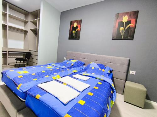 a bedroom with a bed with a blue comforter at Deas Apartments in Tirana in Tirana
