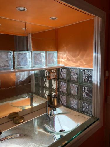 une salle de bain avec un lavabo et un miroir dans l'établissement Maison Bourgeoise années 50, à Haybes