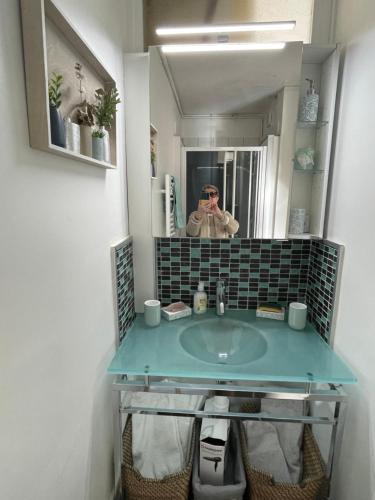 un homme prenant une photo d'un lavabo dans la salle de bains dans l'établissement Le Baulois, à La Baule