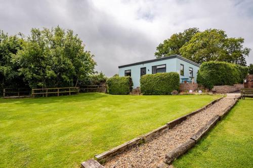Una casa con un césped verde delante de ella. en TheFunkyPigsty, en Coleford