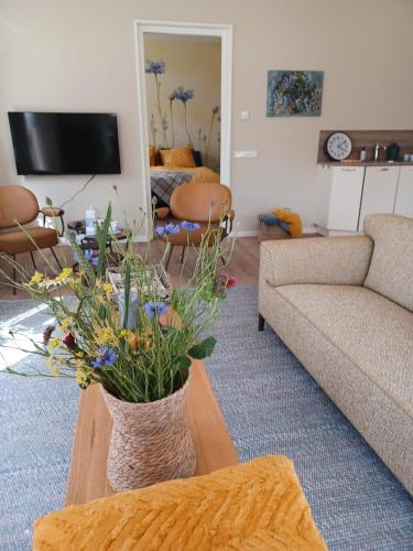 a living room with a vase of flowers on a table at B&B De Korenbloem in Noordbroek