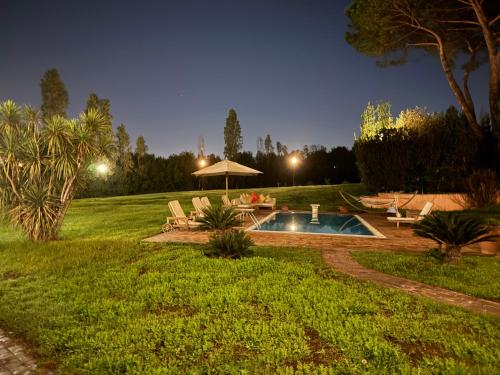 a backyard with a pool and a table and chairs at Villa Bovari - Appia Antica in Rome