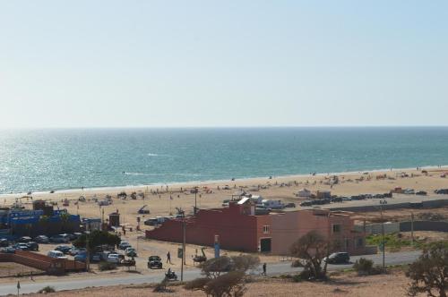 a beach with a lot of people and the ocean at Pearl Surf Camp Morocco in Agadir