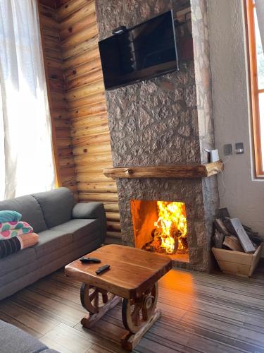 a living room with a couch and a fireplace at Cabañas El Potrero in Creel