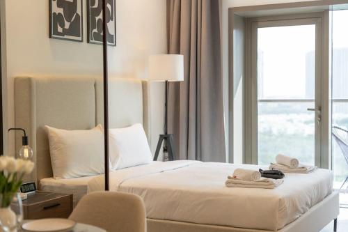 a hotel room with a bed and a window at Free housekeeping visits during your stay - StayShort - Awesome Studio at Park View Tower in JVC with Skyline Views in Dubai