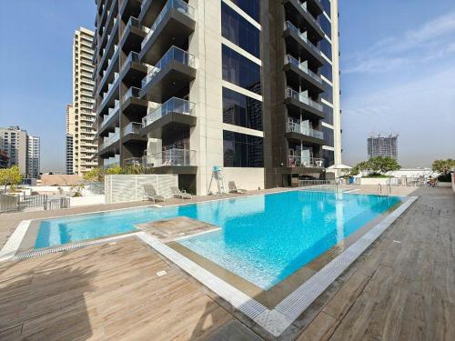 a large swimming pool in front of a building at Free housekeeping visits during your stay - StayShort - Awesome Studio at Park View Tower in JVC with Skyline Views in Dubai