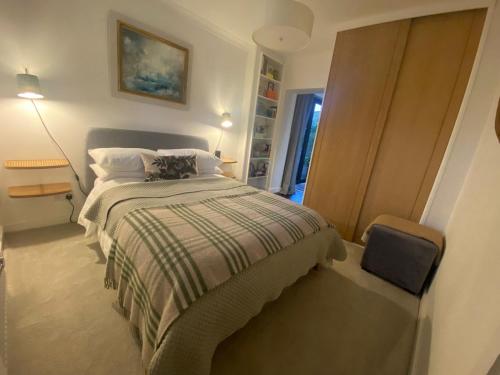 a bedroom with a bed with a striped blanket at The Stables Templenewsam in Whitkirk