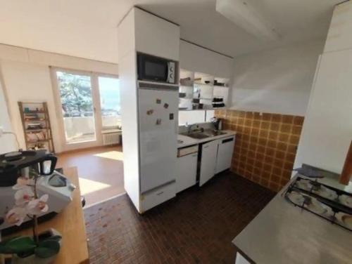 a kitchen with a white refrigerator and a sink at Lovely room, 15 min from center, mountain view in Zürich