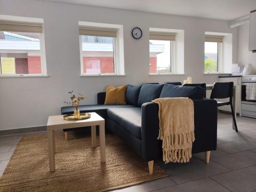 a living room with a blue couch and a table at Cozy house with 2 bedrooms on the sea coast in Assens