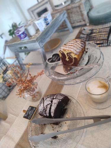a table with two plates of cake and a cup of coffee at Grotta dei Puntali B&B in Carini