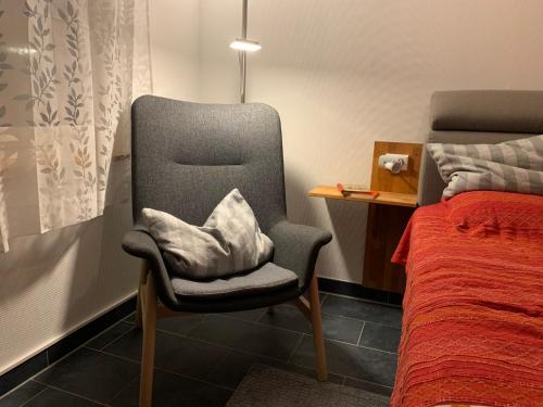 a bedroom with a chair next to a bed at Studio 8 in Bürgel