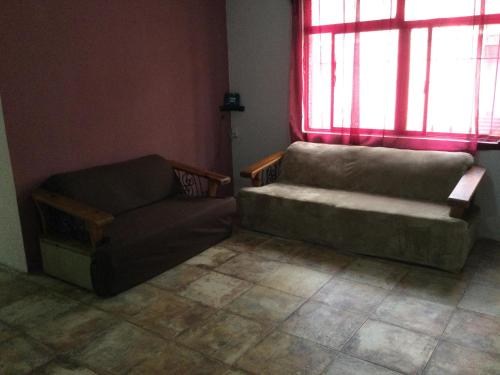 a living room with a couch and a chair at Trotamundo Oaxaca Hostel in Oaxaca City