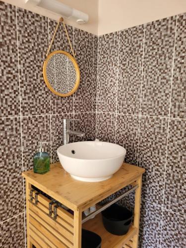 a bathroom with a white sink on a wooden table at Le Triton in Deshaies