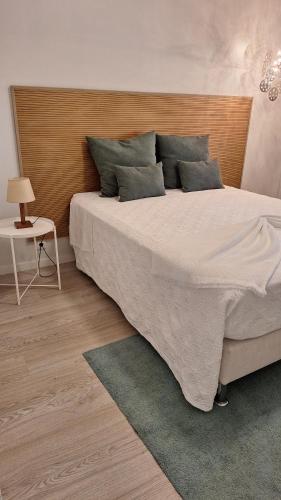 a bedroom with a large bed with a wooden headboard at Pombal Suite in Pombal