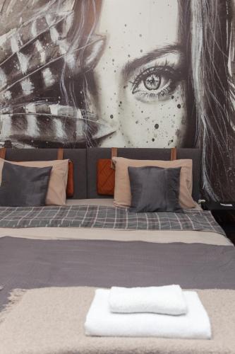 a wall with a mural of a woman with an eye at Red Clay Apartments City Club in Belgrade