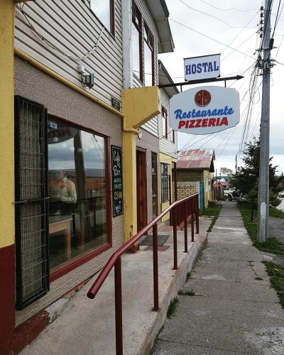 a building with a sign on the side of a street at Hostal Alcázar in Puerto Natales