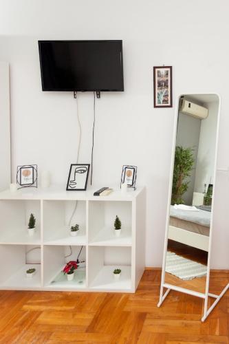 a white shelf with a tv and a mirror at Red Clay Apartments City Club in Belgrade