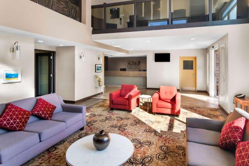 a living room with couches and red chairs at Best Western Plus Osoyoos Hotel & Suites in Osoyoos