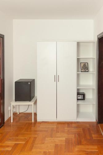 a living room with white cabinets and a tv at Red Clay Apartments City Club in Belgrade