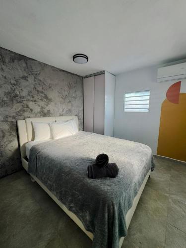 Un dormitorio con una cama con un sombrero negro. en Comfortable Home for 6 Near Airport & Beaches, en Carolina