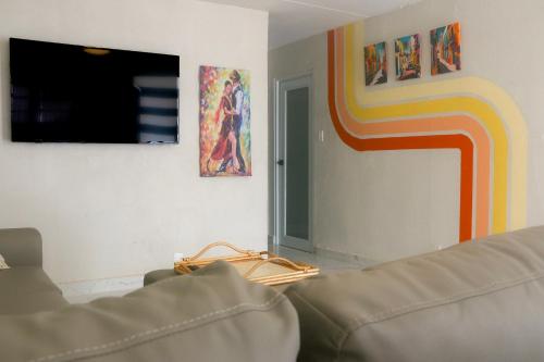 a living room with a couch and paintings on the wall at Relaxing Retreat for 5 Close to Beach & Airport in Carolina