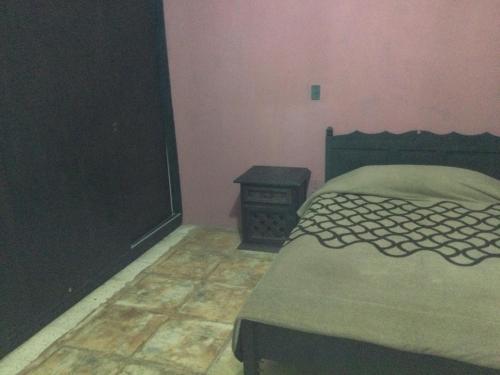 a bedroom with a bed and a side table at Trotamundo Oaxaca Hostel in Oaxaca City